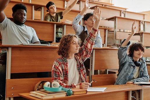 boys in class with raised hands